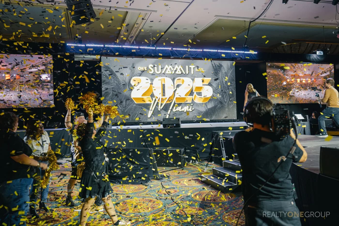 The Realty ONE Group Philippines team celebrating on stage at Summit 2025